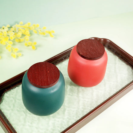 Aurora ceramic jars with wooden lids in teal and coral on decorative tray