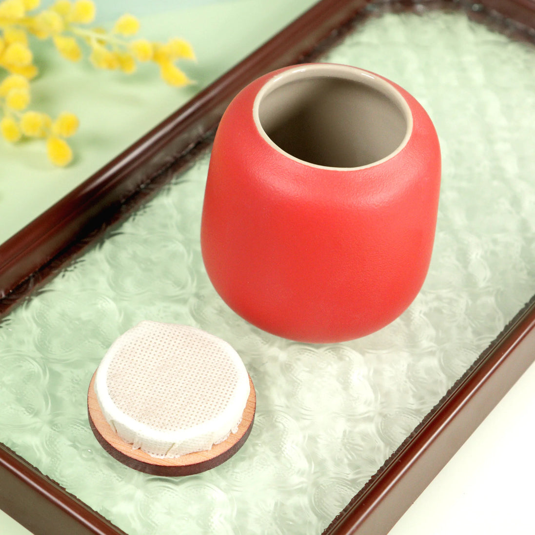 Aurora jar in coral with bamboo lid and pumice stone on decorative tray