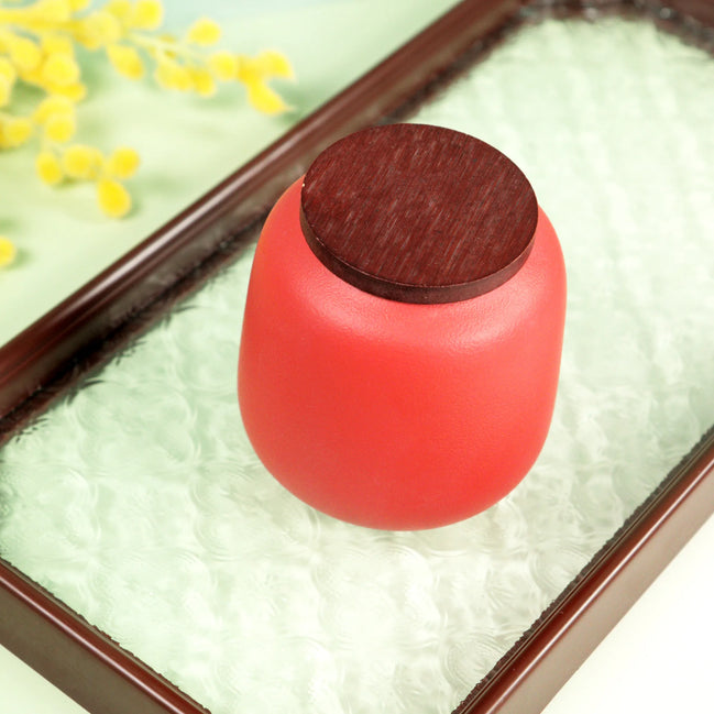 Aurora jar in coral pink with wooden lid on decorative tray