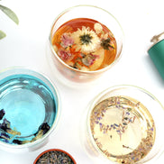 Blooming flower tea in glass cups with blue butterfly pea and herbal infusions