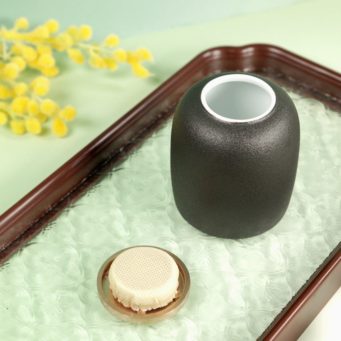 Kin ceramic jar in matte olive green with timber lid on decorative tray