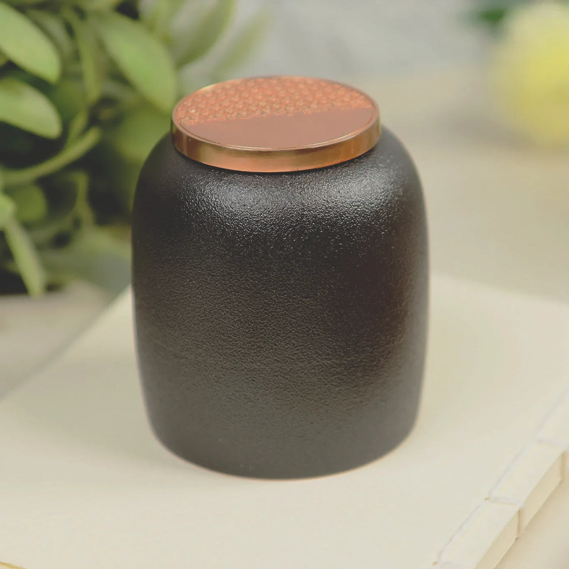 Kin Jar 220 black ceramic incense storage jar with rose gold copper lid on marble surface