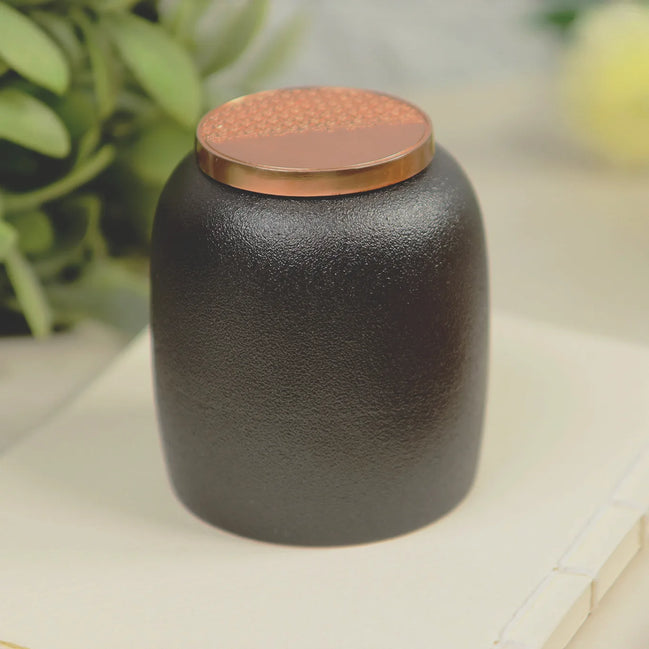 Kin Jar 220 black ceramic incense storage jar with rose gold copper lid on marble surface