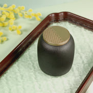 Kin jar in forest green with textured gold lid on decorative tray