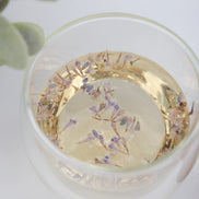Lavender herbal tea in clear glass cup with dried purple flowers