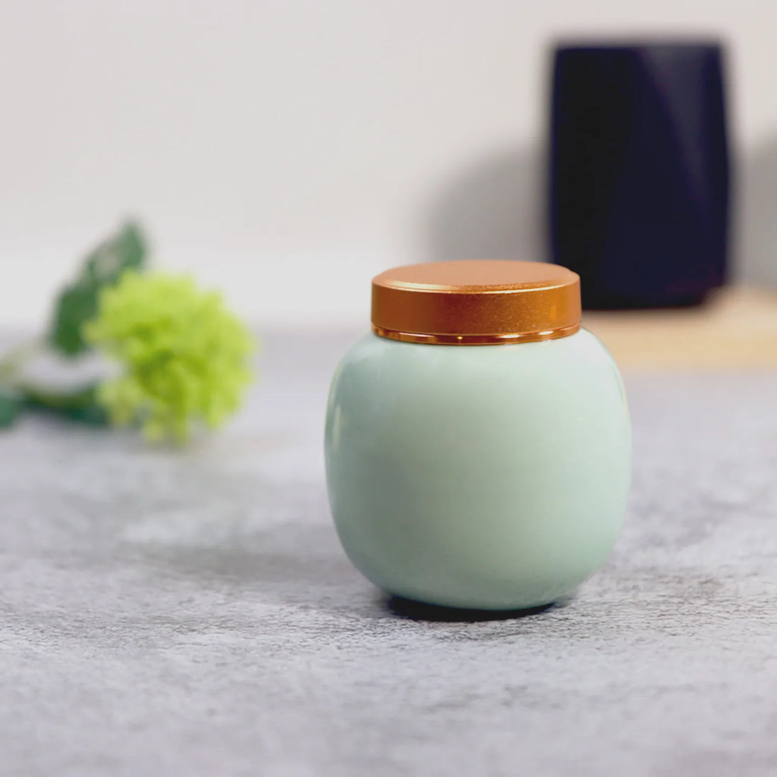 Lily ceramic storage jar in sage green with bamboo lid on marble surface