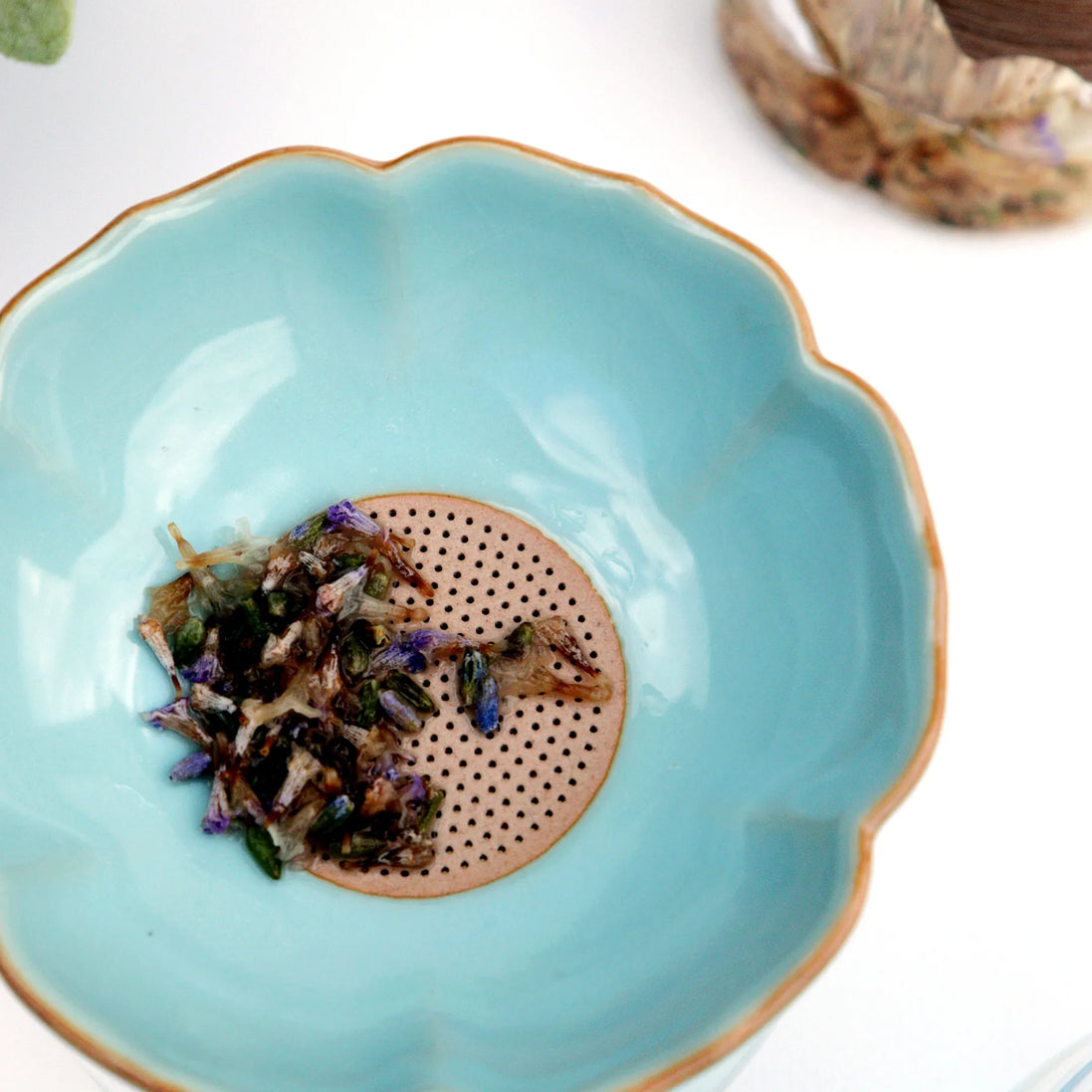 Loose leaf herbal tea blend with lavender in turquoise ceramic bowl with gold rim