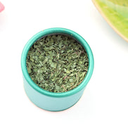 Loose leaf peppermint tea in turquoise storage container top view