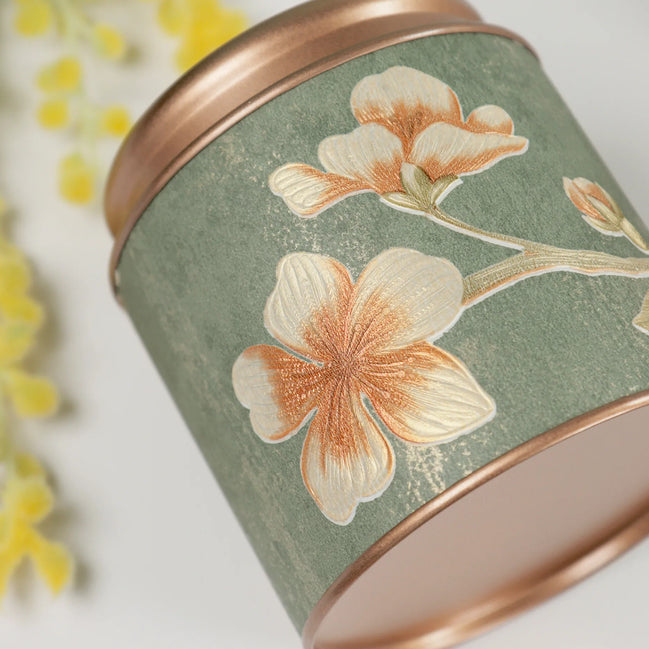 Sage green Manifestation Bloom candle with copper floral embroidery detail and rose gold lid