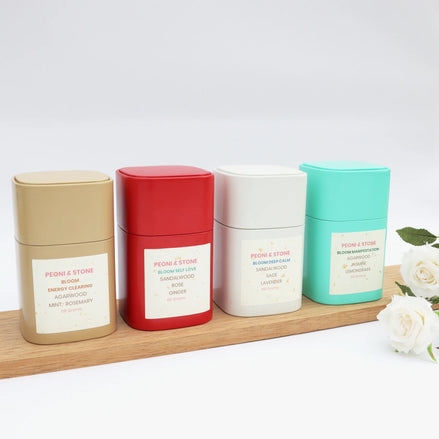 Peoni & Stone Bloom candle collection in four scents on wooden board with white roses