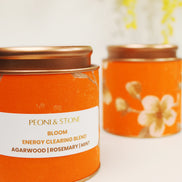 Four colorful Peoni & Stone Bloom aromatherapy jars displayed on wooden tray including yellow Energy Clearing blend