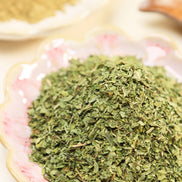 Gold-capped Peoni & Stone Bloom candle jar with agarwood, mint, and rosemary blend on wooden shelf