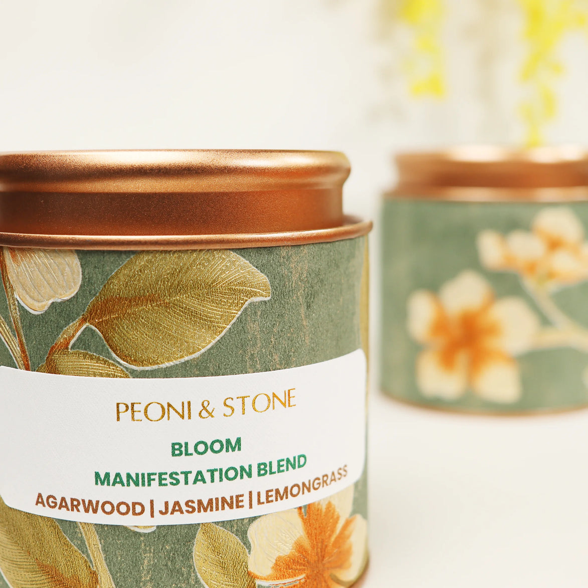 Sage green tin candle with gold floral design and copper lid featuring jasmine, agarwood, and lemongrass scent