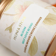 Three white bowls containing dried sandalwood chips, rose petals, and ginger pieces on wooden surface