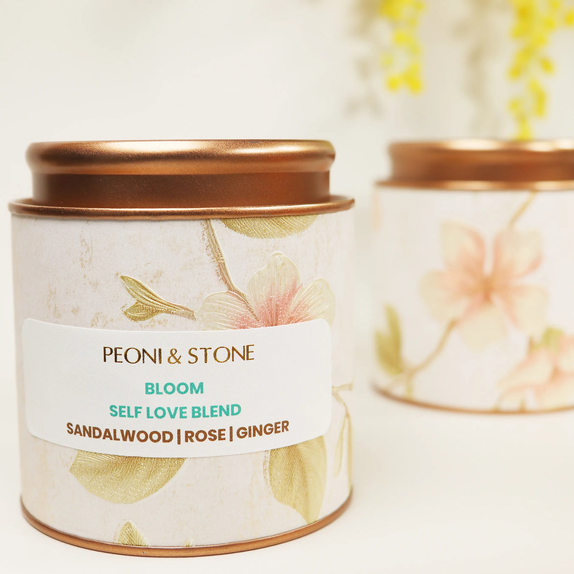Peoni & Stone Bloom blend tin with copper lid featuring floral design and sandalwood, rose, ginger ingredients