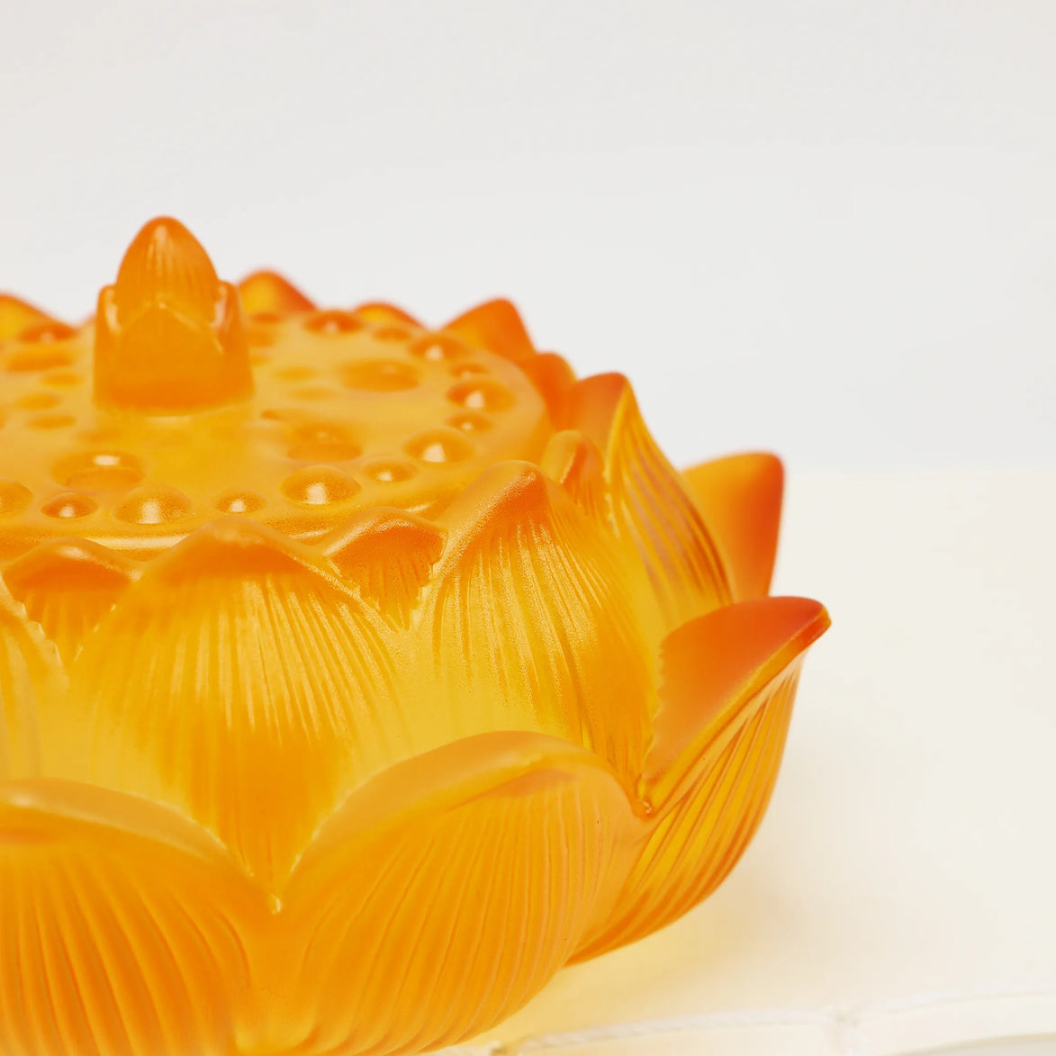 Amber glass lotus flower incense burner with detailed petal engravings and decorative textured lid