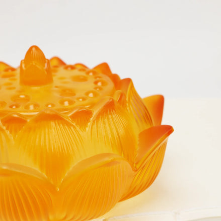 Amber glass lotus flower incense burner with detailed petal engravings and decorative textured lid
