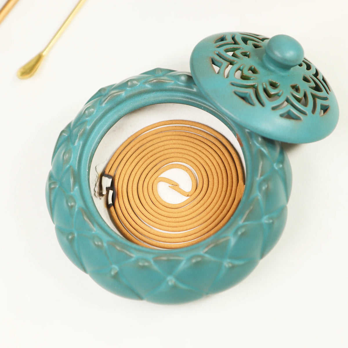Turquoise ceramic incense burner with carved decorative lid and spiral coil holder inside