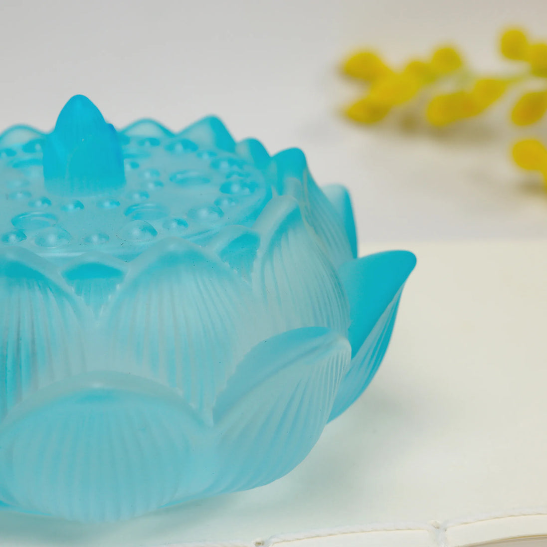 Translucent blue glass lotus flower incense burner with detailed petal engravings and sealing lid