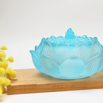 Translucent dawn blue lotus-shaped glass incense burner with decorative lid on wooden stand