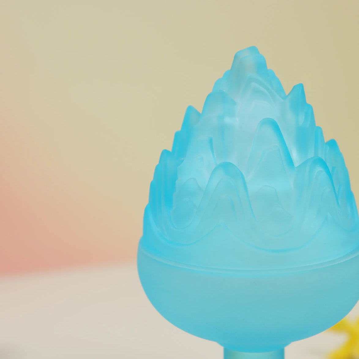 Translucent blue glass boshan incense burner with lotus base and ornate flame-shaped lid on white surface