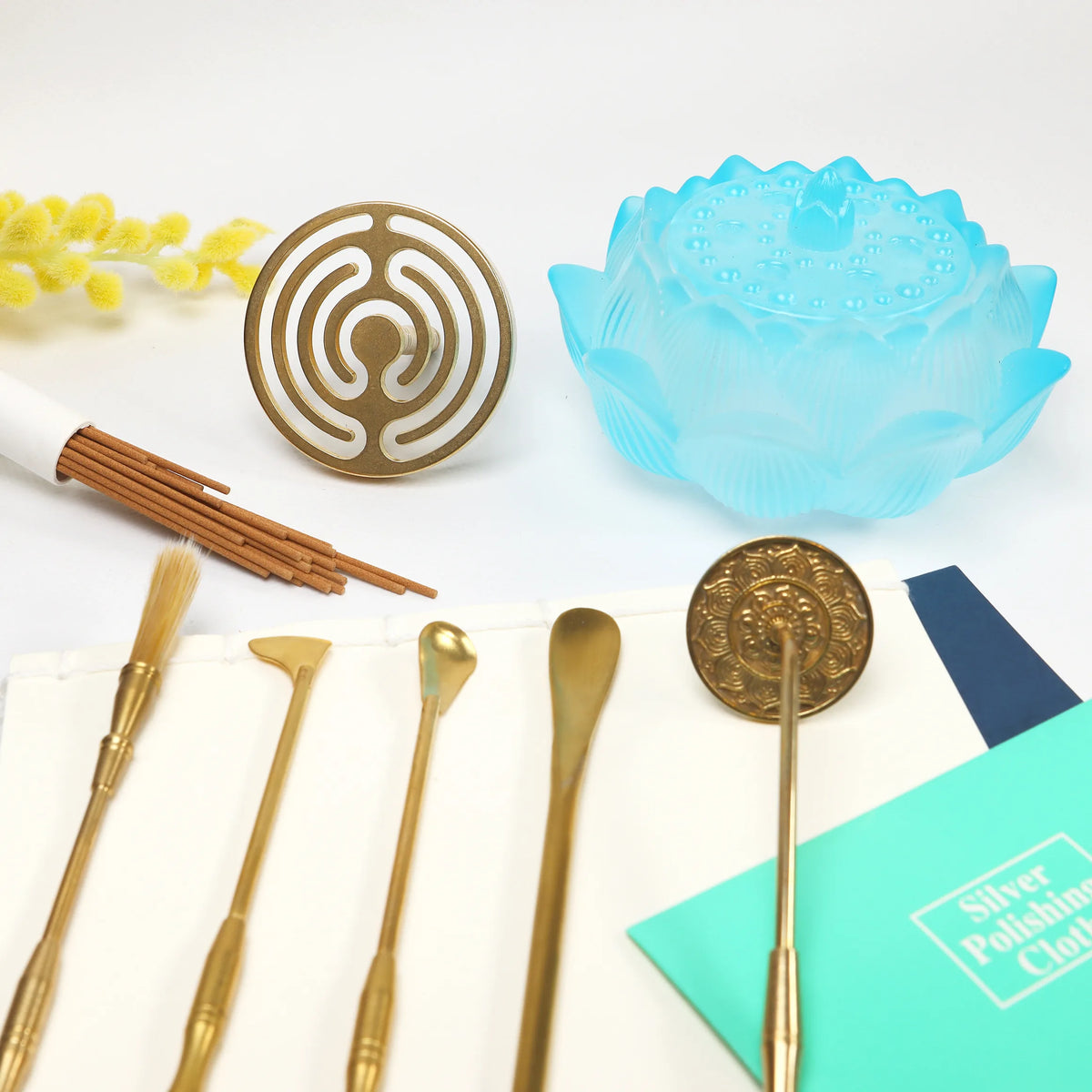 Blue glass lotus holder with brass sealing tools and ornate double happiness seal on white marble surface