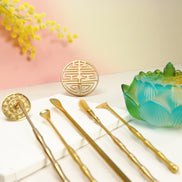 Three ombre glass lotus incense burners in blue, orange, and turquoise displayed on wooden board with flowers