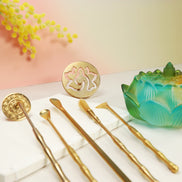 Turquoise to yellow ombre lotus glass burner with brass tools, wooden incense sticks, and labyrinth coaster