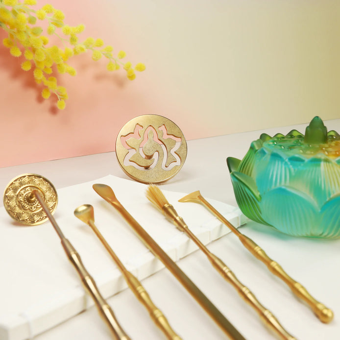 Turquoise to yellow ombre lotus glass burner with brass tools, wooden incense sticks, and labyrinth coaster