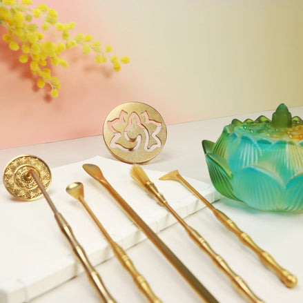 Turquoise to yellow ombre lotus glass burner with brass tools, wooden incense sticks, and labyrinth coaster