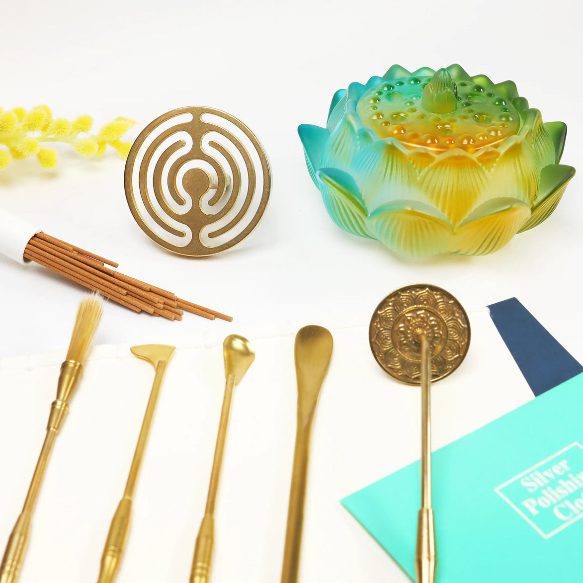 Gold brass wax sealing tools with pink lotus stamp and green ombre glass lotus container on white surface