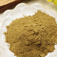 Fine golden-brown incense powder in white scalloped bowl, showing natural hand-blended texture