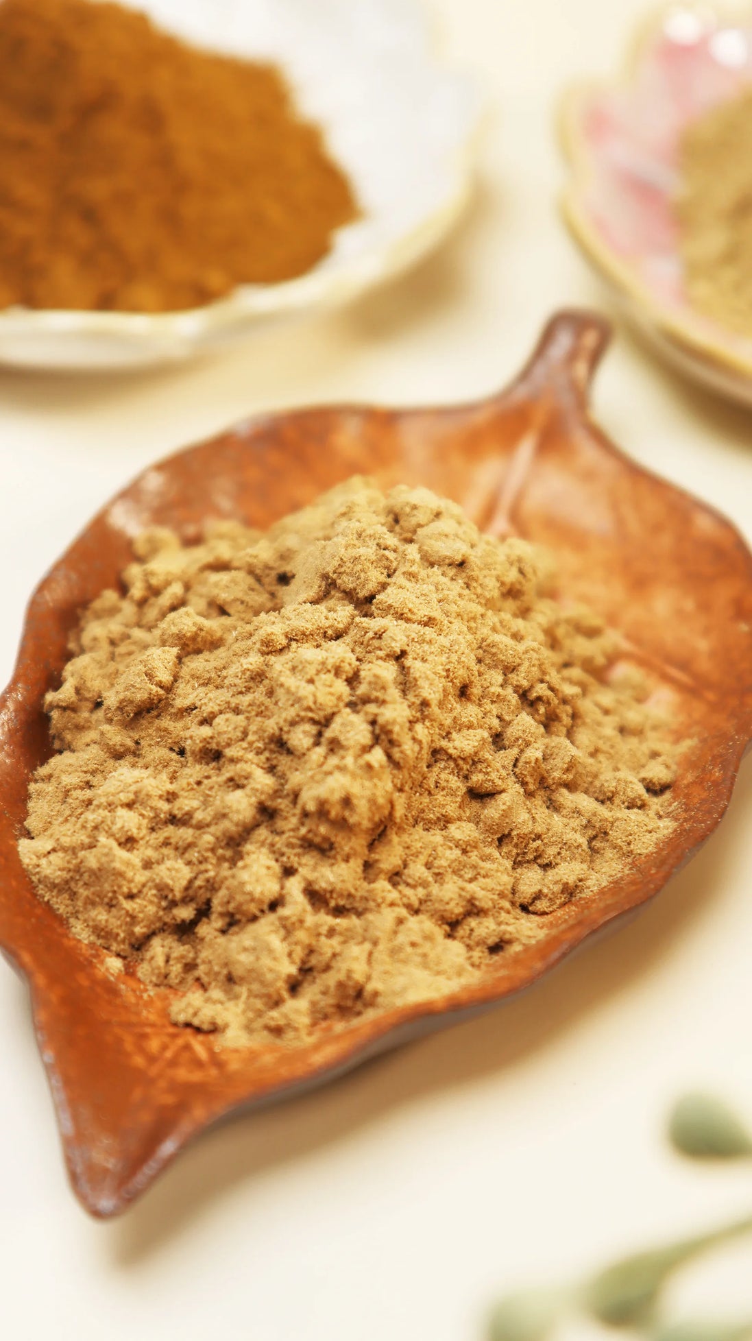 Blue and white glass bottle of Peoni & Stone Energy Clearing incense with gold decorative cap and yellow flowers above