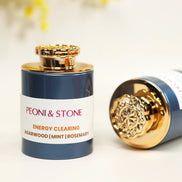 Three ceramic bowls filled with natural brown incense powder blend on wooden cutting board with green leaves