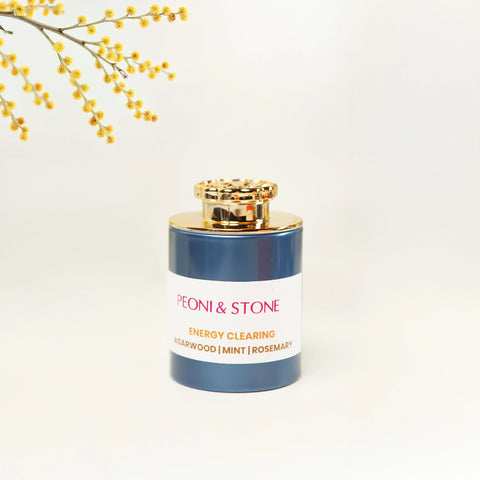 Golden brown incense powder in wooden leaf-shaped dish with bowls of ingredients in soft-lit background