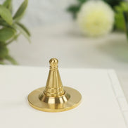 Golden copper incense cone tool with heavy round base and tapered cone shape on white surface