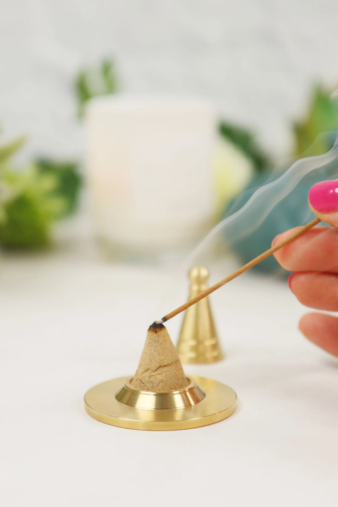 Gold-toned copper incense cone maker with powder blend on brass base, hand lighting with incense stick