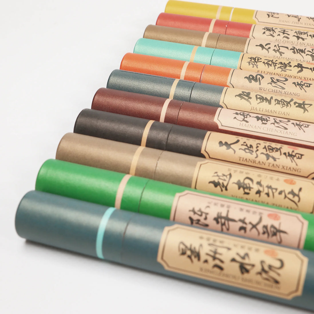 Row of colorful natural incense sticks with Chinese calligraphy labels in various earth tones and pastels