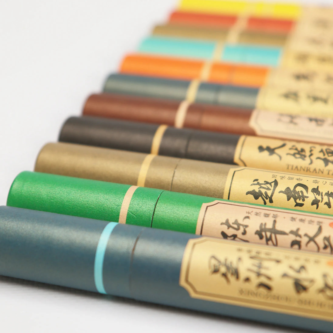 Colorful all-natural incense sticks with kraft paper labels featuring Asian calligraphy arranged in rows