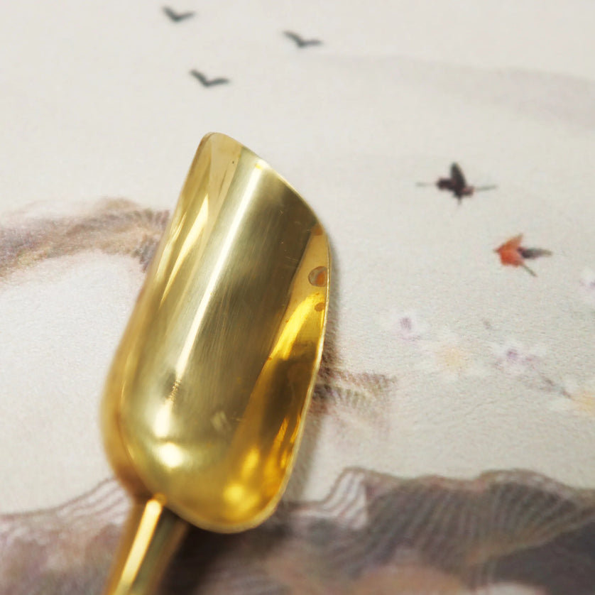 Golden brass polishing cloth with smooth reflective surface positioned against neutral background