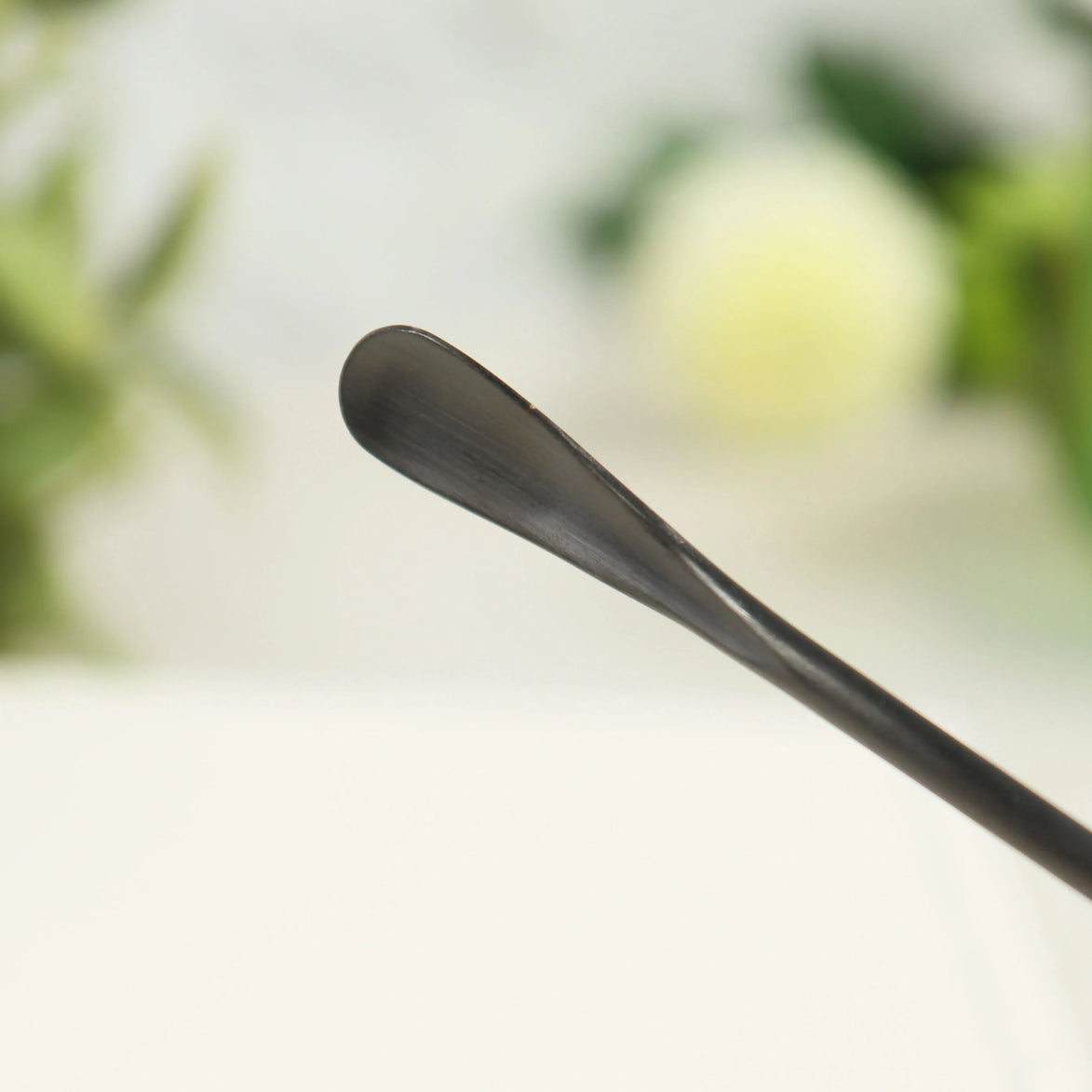 Matte black stainless steel incense scoop with curved bowl end for ash removal and powder handling