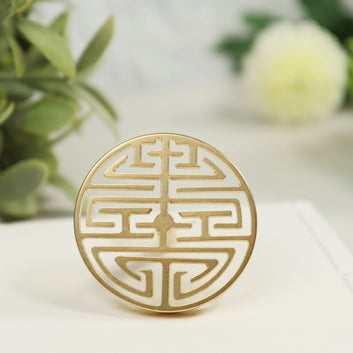 Gold brass circular seal with intricate double happiness Chinese symbol featuring geometric maze-like patterns