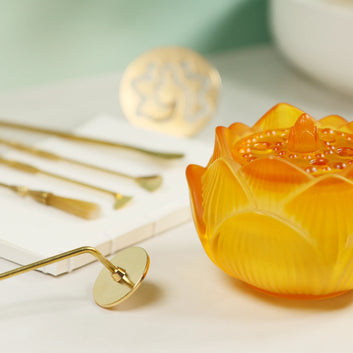 Two brass lotus flower incense stamps with long handles and intricate mandala designs on circular heads