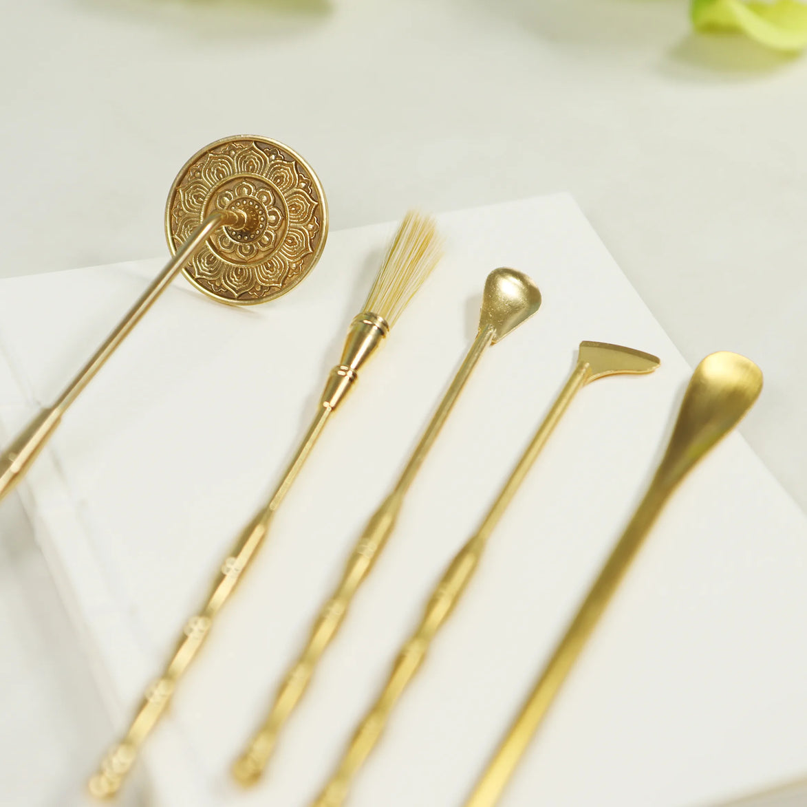 Five brass incense sealing tools with gold finish including ornate lotus stamp, brush, spade, spoon and scoop