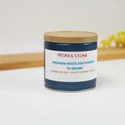 Blue jar with gold lid containing Peoni & Stone Premium White Ash Powder 70 grams on wooden surface