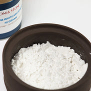 Fine white ash powder in dark bowl with Peoni & Stone container showing 70 gram package