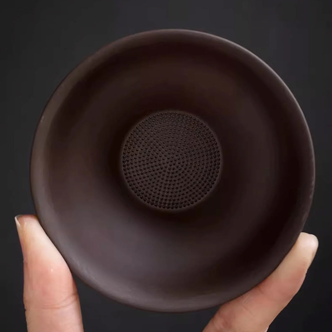 Purple clay tea strainer with fine mesh filter held in hand showing interior detail