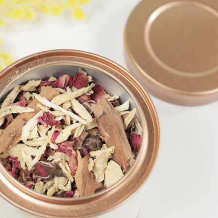 Self Love Bloom herbal tea blend in rose gold tin with dried rose petals and botanicals